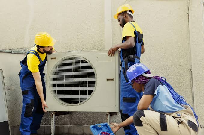 Team installing a residential outdoor air conditioning unit