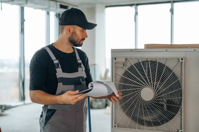 HVAC technician reviewing an outdoor residential air conditioning unit