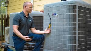 Technician measuring an outdoor residential HVAC unit