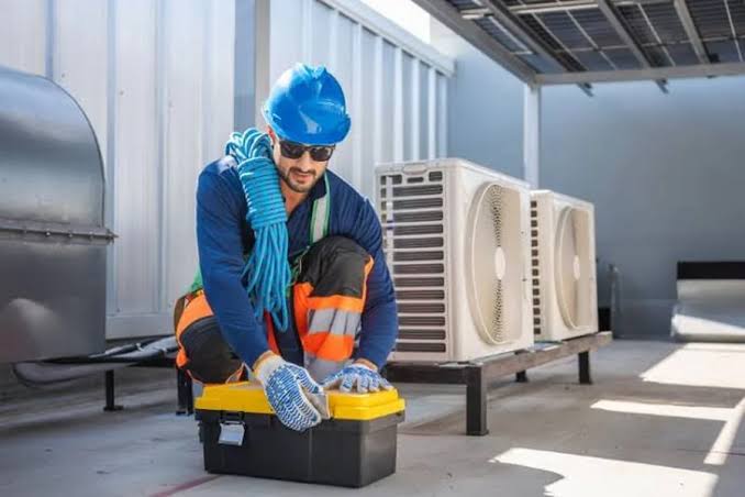 HVAC technician preparing tools near rooftop cooling equipment